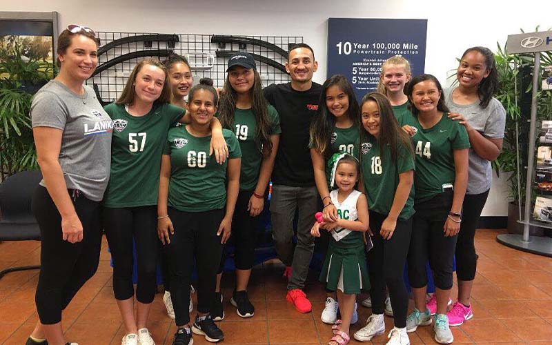 Peter's Special Project and UFC Champion Max Holloway posing wwith local youth sports team